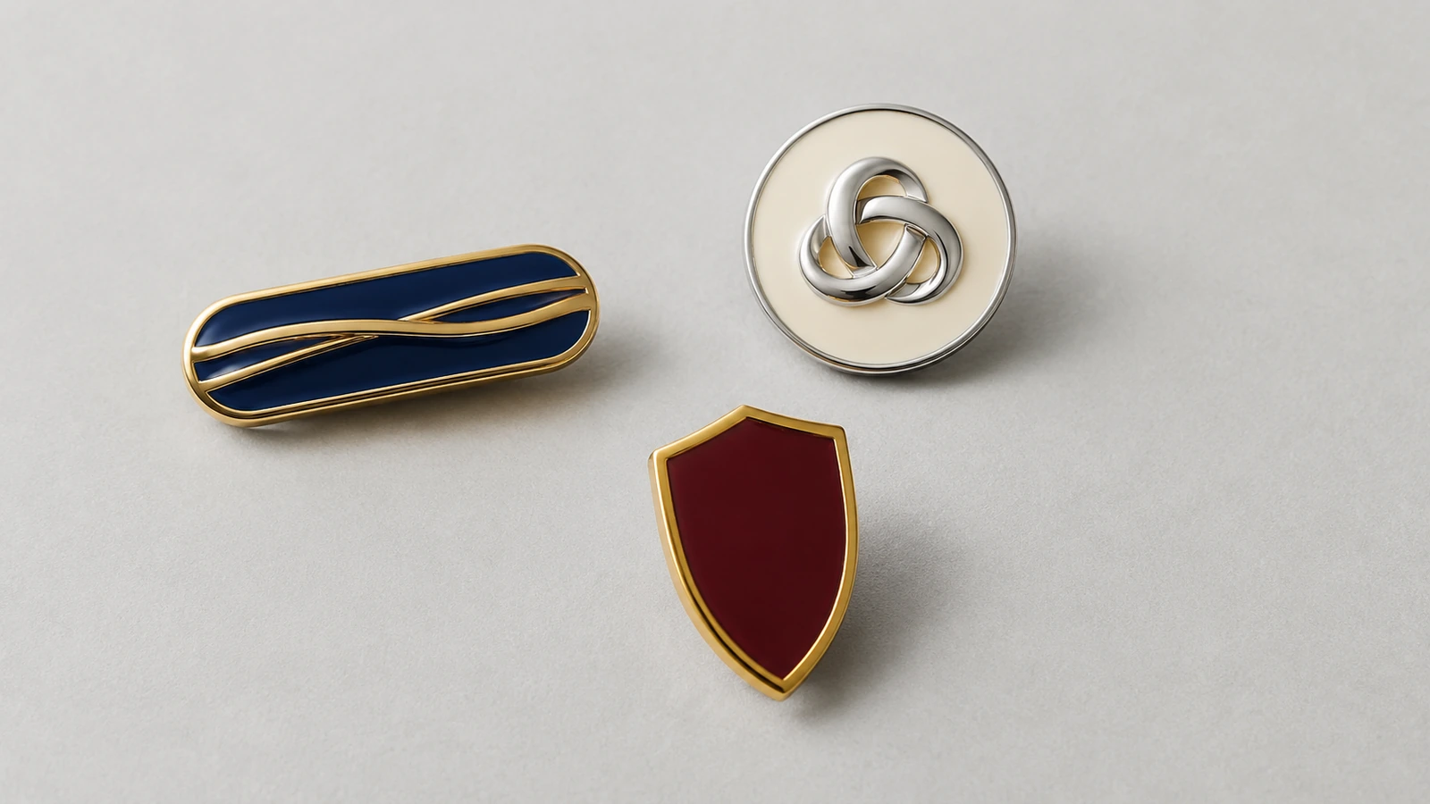 Pin's vierges minimalistes avec des rubans de métal en relief lisses et une boucle entrelacée qui évoquent la typographie sans aucun caractère lisible