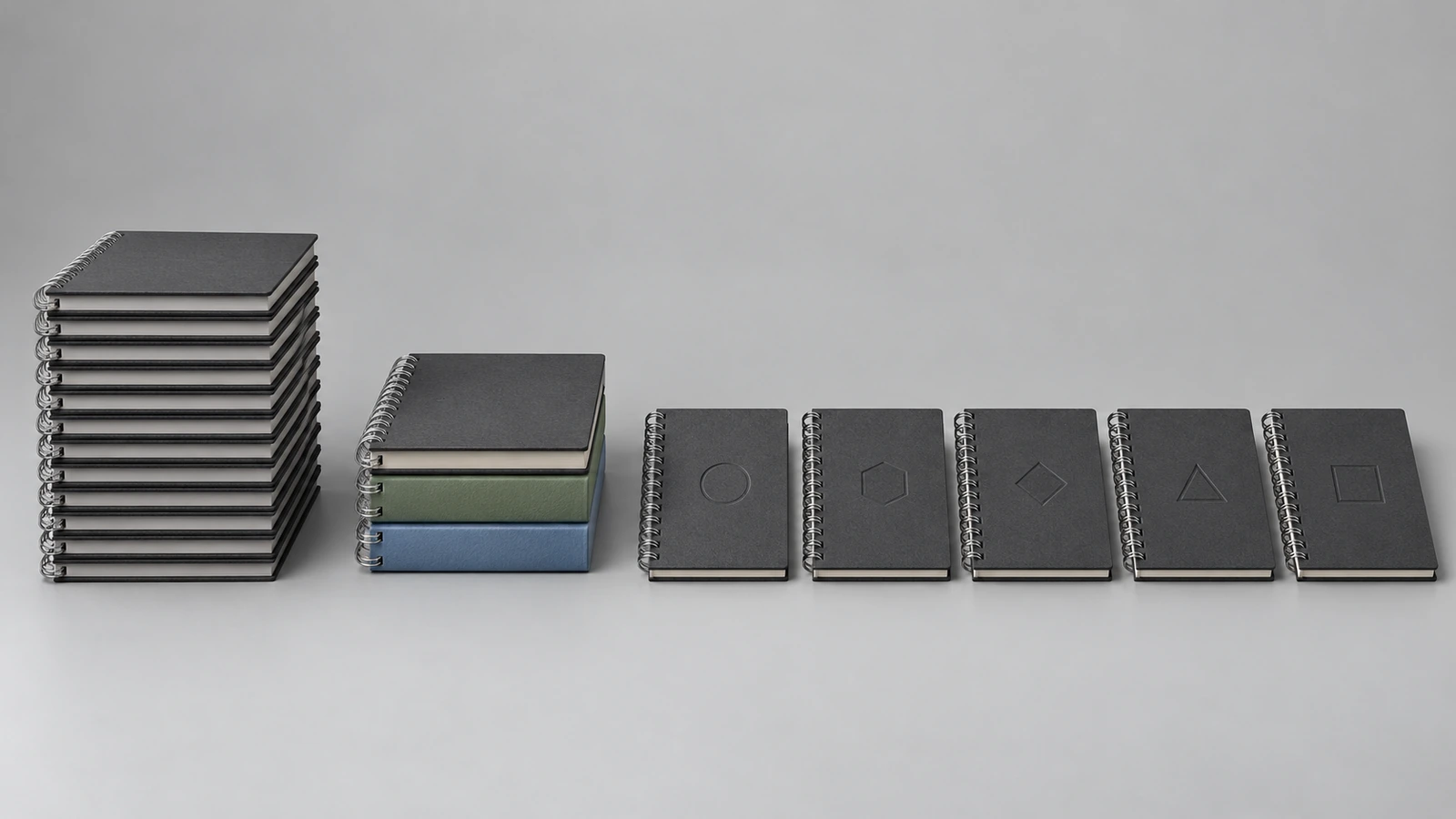 Trois groupes de carnets à reliure métallique illustrant une personnalisation croissante : une pile identique, une pile répartie en trois couleurs de couverture et une rangée de carnets marqués chacun d'un petit emblème différent