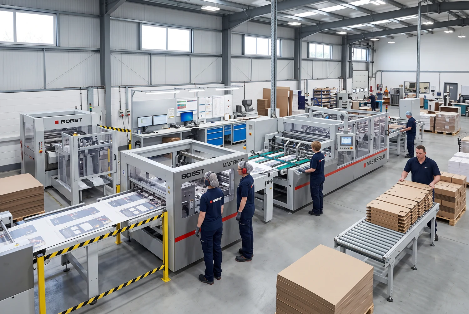 Ouvriers près de machines de transformation de cartons et de piles de carton plat dans une usine