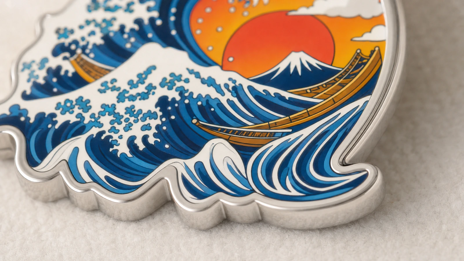 Gros plan d’un porte-clés métallique découpé avec des vagues bleues, un soleil orange, une montagne et un bateau