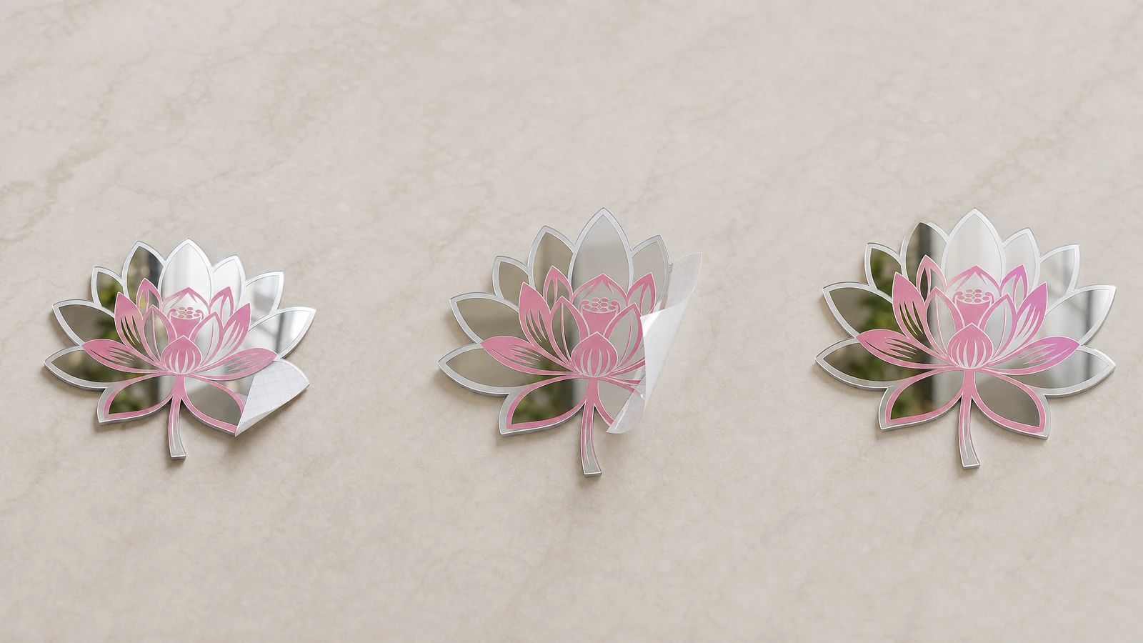 Décalques miroir lotus présentés en trois tailles Trois décalques miroir en forme de lotus, de tailles différentes, affichés sur un mur clair