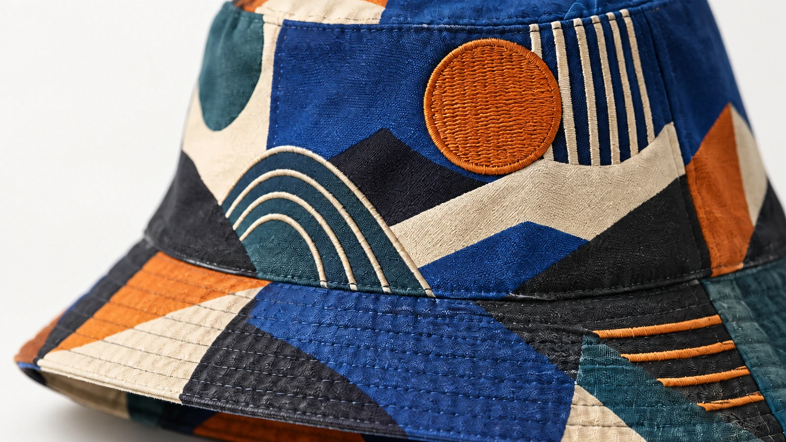 Gros plan sur le tissu à motifs du bob, la visière cousue et la broderie circulaire orange