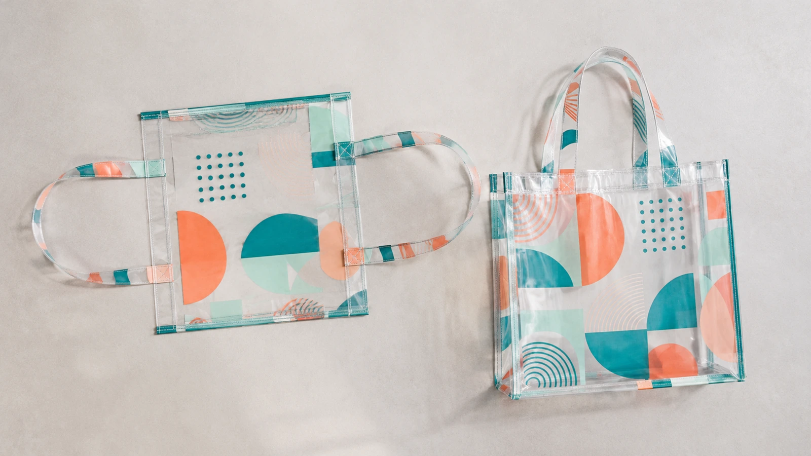 Sac fourre-tout transparent à plat, anses étalées, à côté d’un sac fini debout