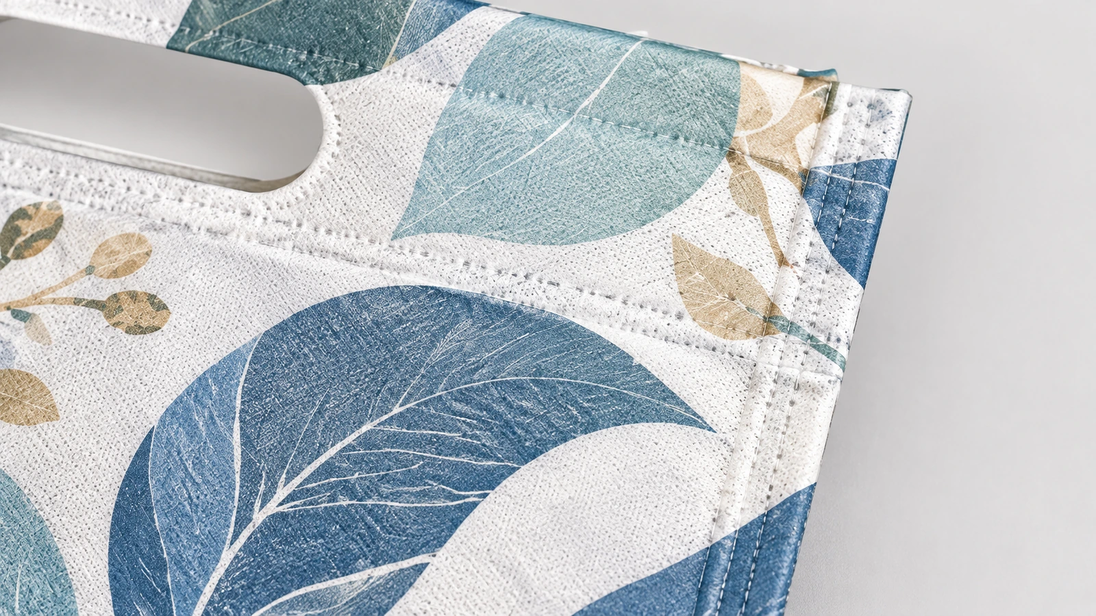 Gros plan sur la surface d'un sac à motif de feuilles et sur l'ouverture de poignée à découpe