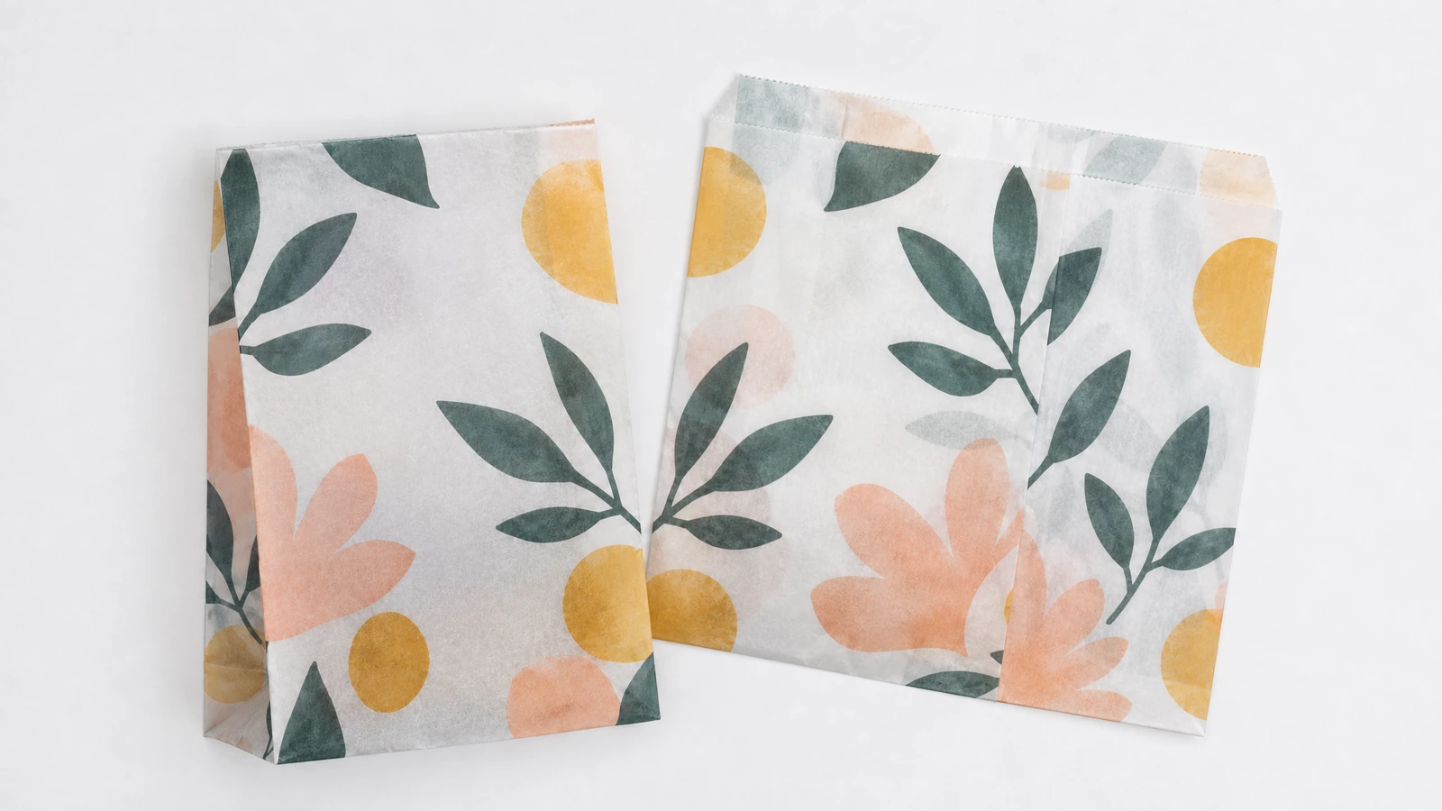 Deux sacs en papier imprimés de motifs floraux, montrant les faces avant et arrière