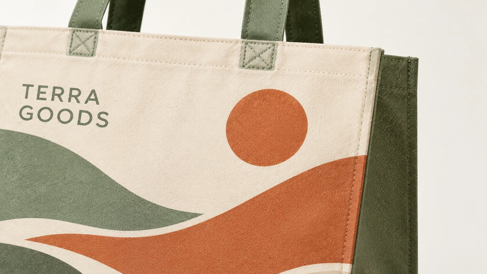 Gros plan d'un cabas à motif paysage avec inscription TERRA GOODS et anses vertes cousues