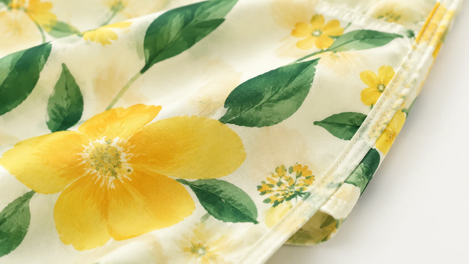 Gros plan du tissu floral jaune et du bord cousu d'un sac fourre-tout