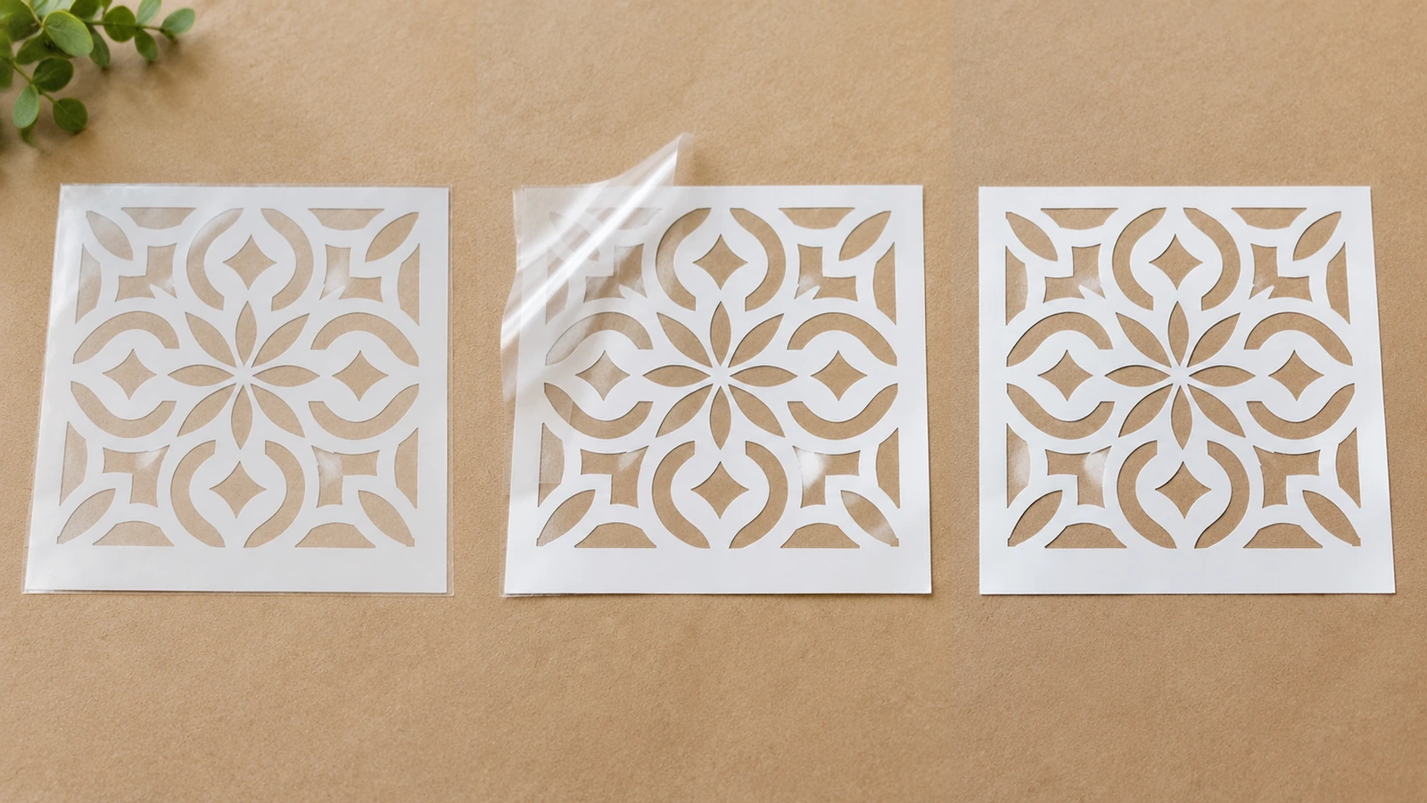 Trois feuilles de pochoir floral blanches disposées côte à côte, avec leurs couches transparentes visibles