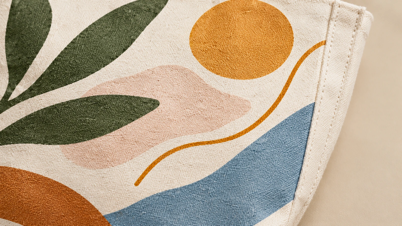 Gros plan sur des motifs de feuilles et des motifs abstraits sur tissu de coton, à côté d'un bord cousu