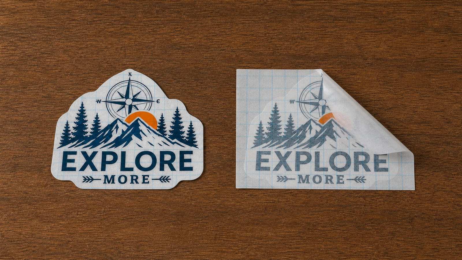 Deux motifs de décalques assortis, montagne et boussole, sur une table en bois, l'un recouvert d'un film quadrillé partiellement soulevé